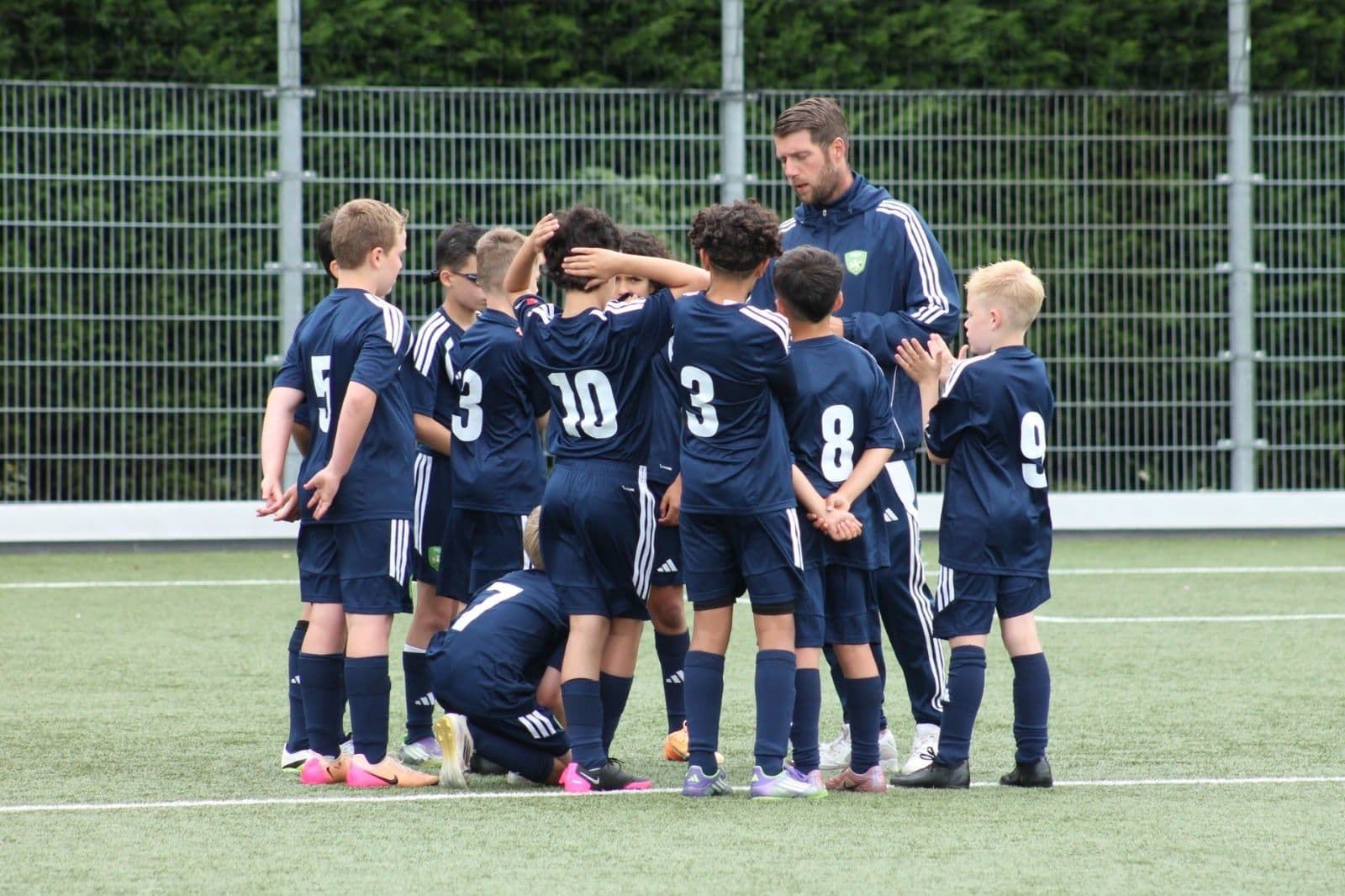 Footure-trainer bespreekt de training met een groep jeugdspelers.